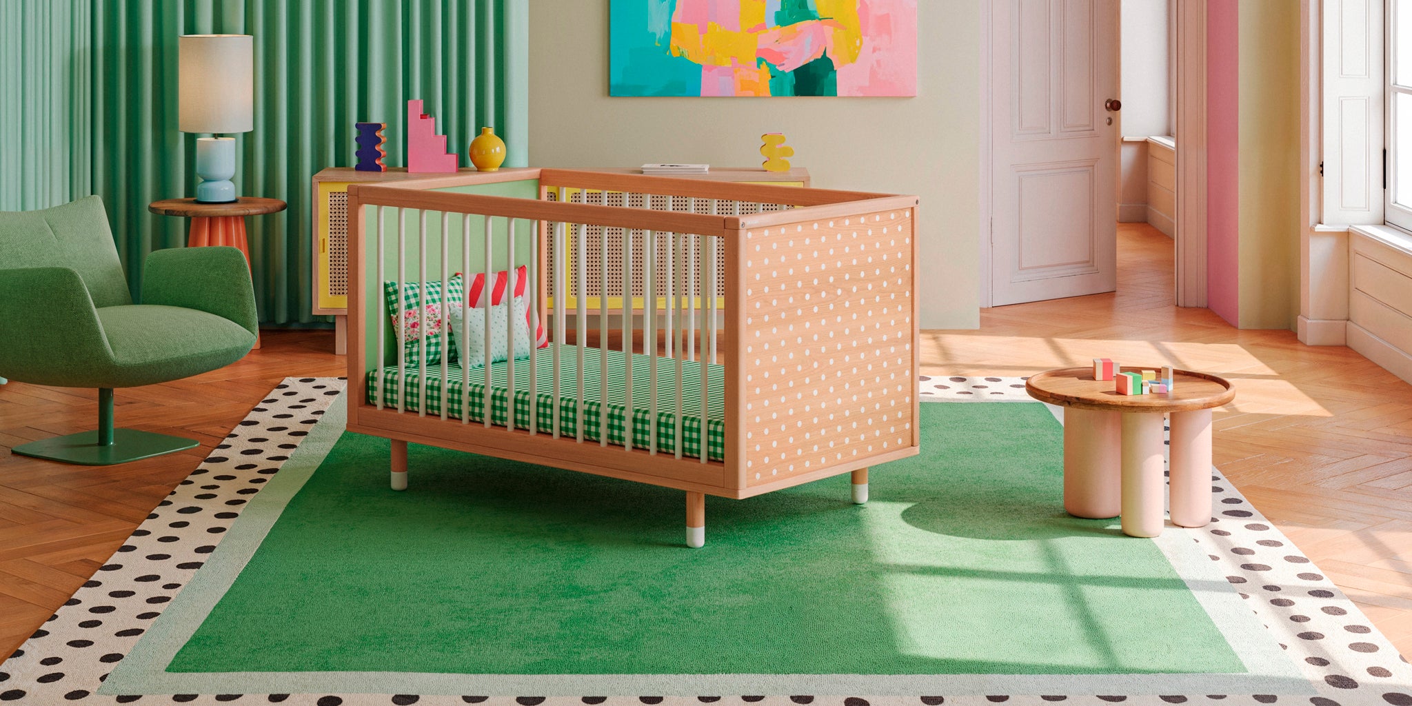 A customisable, designer cot on a green rug in a beautiful nursery