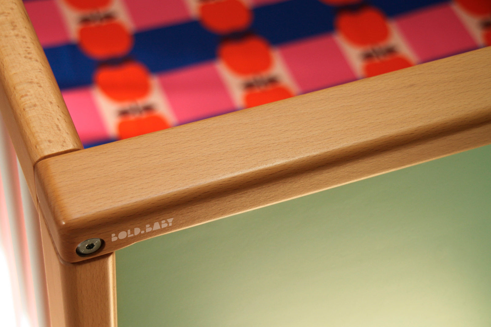 Corner detail of a customisable cot with a colourful sheet