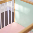 A close up of a mint coloured panel inside a cot