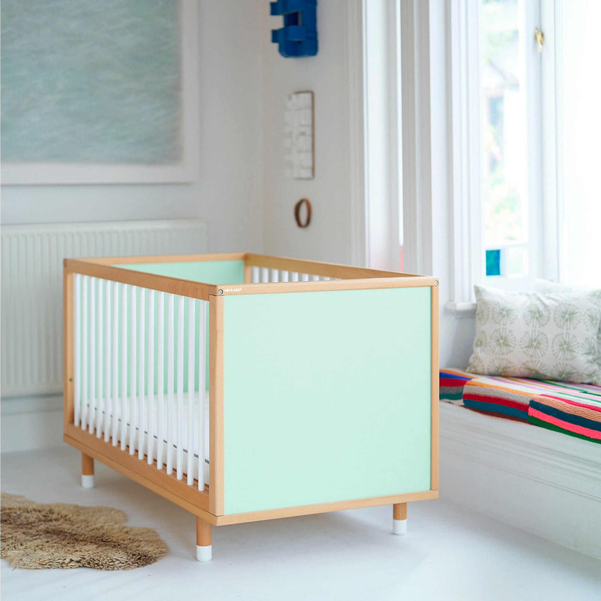 A cot with mint coloured end panels