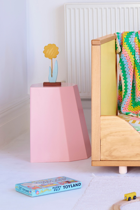 A cot in toddler setting with yellow panel