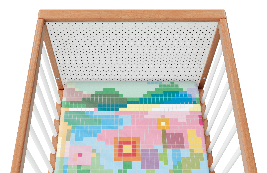 Overhead view of a white cot with colourful sheet