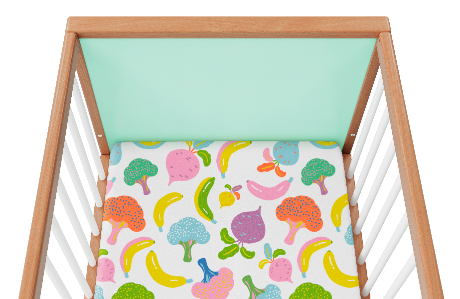 Overhead view of a mint cot and colourful cot sheet