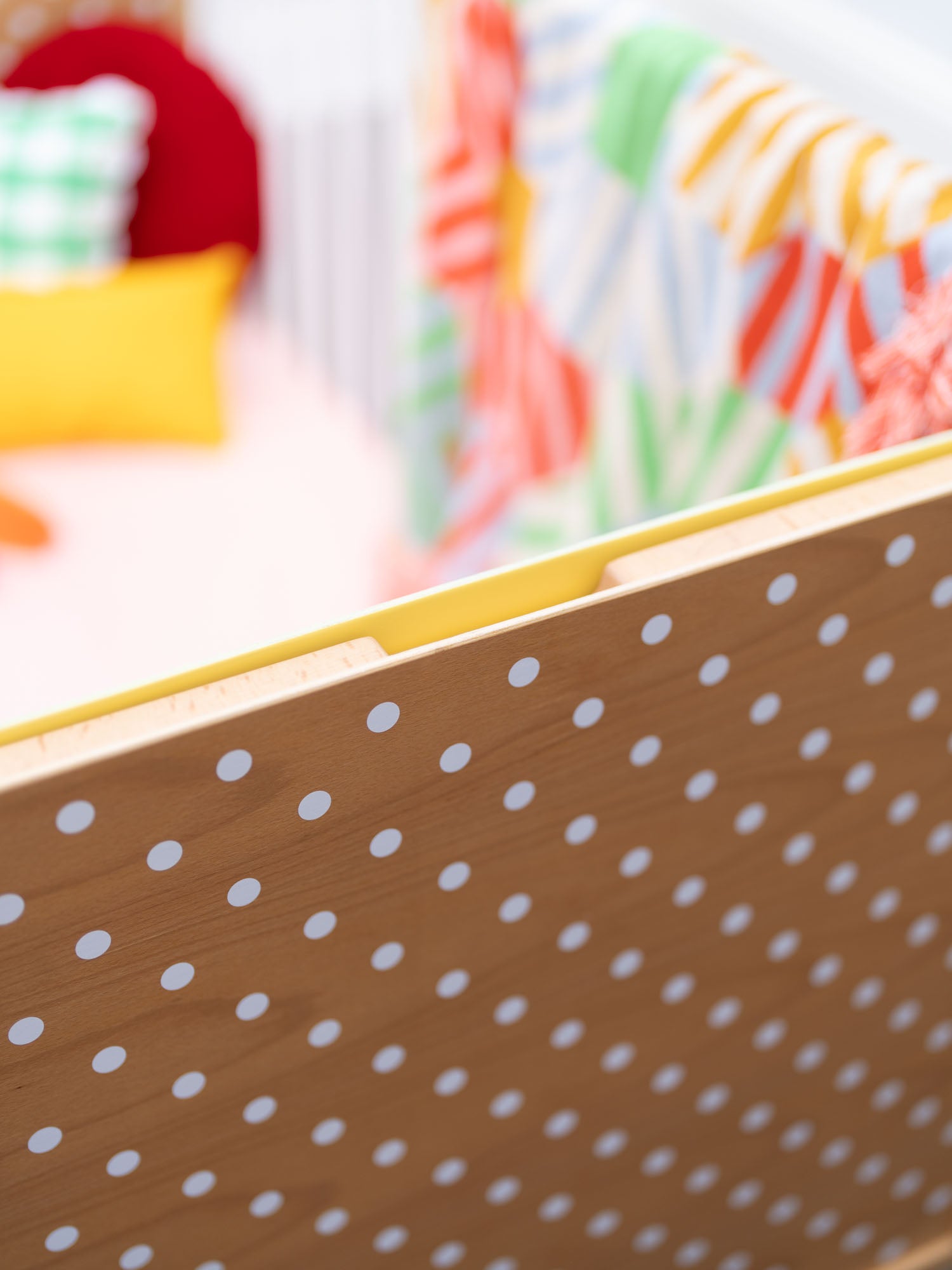 Cot end panel with white dots on wood